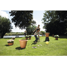Tuinscene met spelende kinderen en plantenbakken.