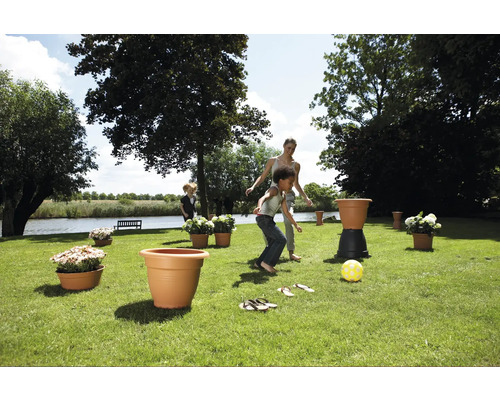 Tuinscene met spelende kinderen en plantenbakken.