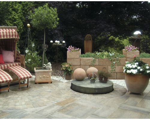 Aangelegde tuin met strandstoel, bestrating en beplanting