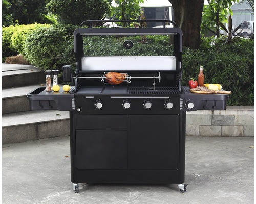 Zwarte gasbarbecue met rotisserie en bijgerechten op bijzettafels in de tuin.