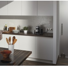 Lichte keuken met werkblad, keukengerei, koffiezetapparaat en tegelachterwand