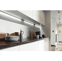 Moderne keuken met werkblad, servies, koffiezetapparaat en onderbouwverlichting