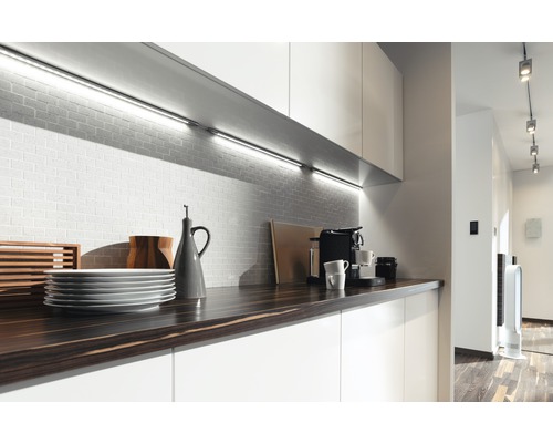 Moderne keuken met werkblad, servies, koffiezetapparaat en onderbouwverlichting