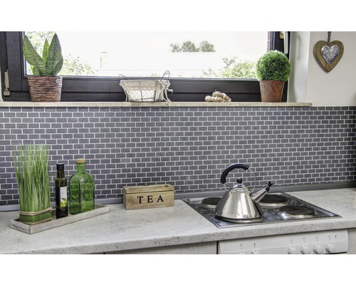 Keukenscène met mozaïektegels, kookplaat, theepot en decoratie