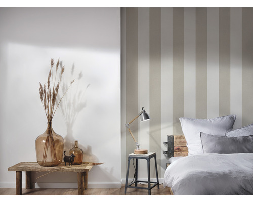Slaapkamer met gestreept behang, bedlamp, decoratie en bed
