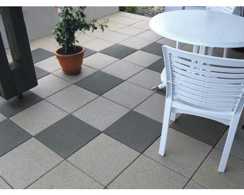 Terras met vierkante betontegels, tuinmeubelen en plant