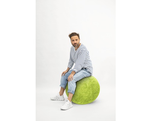 Man zit op een groene zitbal