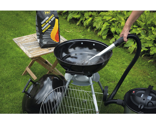 Scene met houtskoolbarbecue, zak houtskool en aszuiger op gazon