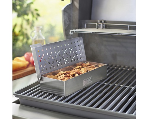 Barbecue met rookbox gevuld met rookhout op grillrooster