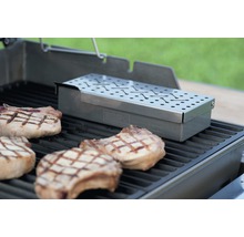 Weber Logo rookbox met varkenskarbonades op een grillrooster