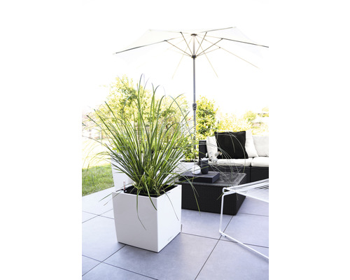 Terrasscène met plantenbak, zithoek en parasol voor buiten