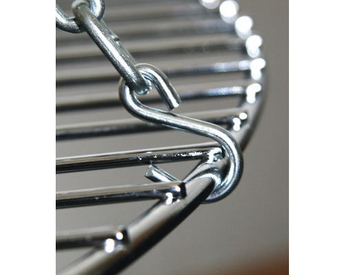 Gedetailleerde opname van een grillrooster met ketting en haken om op te hangen.