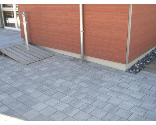 Bestrate binnenplaats met houten hellingbaan en houten wand