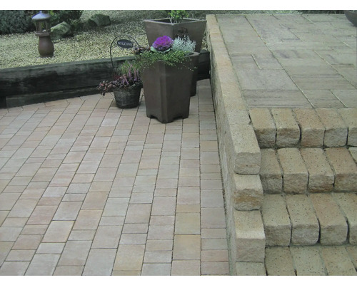 Tuinlandschap met bestrating, trap en beplante potten.