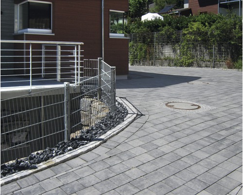 Buitenkant met straatstenen, metalen hek en huis