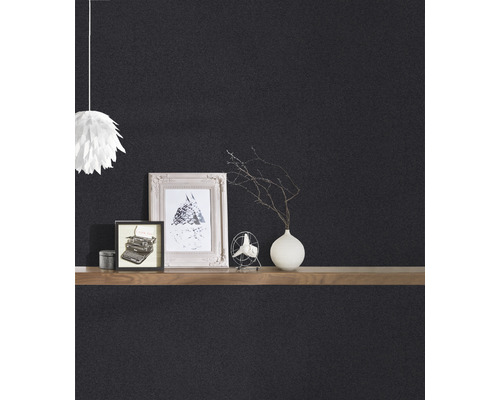 Detailweergave van een zwarte muur met decoratie op een plank