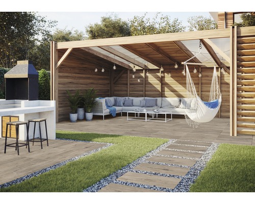 Buitenscène met barbecueplaats, tuinhuis, loungegedeelte en terrastegels