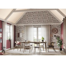 Eetkamer met houten tafel, stoelen en bloemenbehang in een heldere ruimte met schuine daken