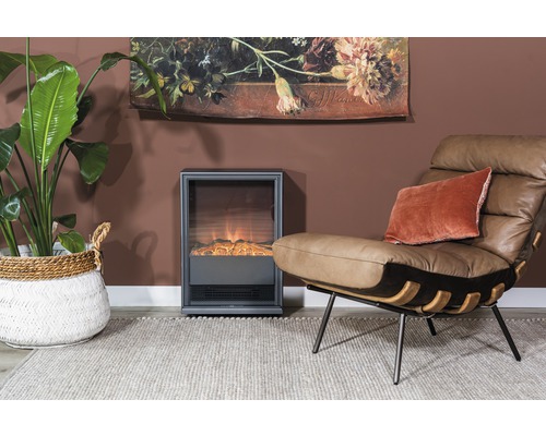 Woonkamer met elektrische open haard, fauteuil, kamerplant en decoratie