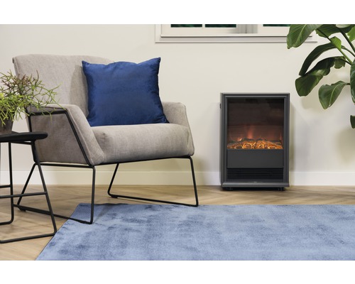 Woonkamer met fauteuil, sierkussen, bijzettafel, kamerplant, vloerkleed en elektrische haard