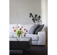 Woonkamer met witte bank, salontafel, bloemenvaas en wanddecoratie