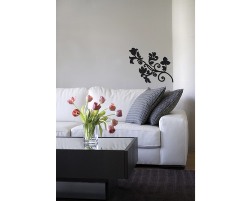 Woonkamer met witte bank, salontafel, bloemenvaas en wanddecoratie