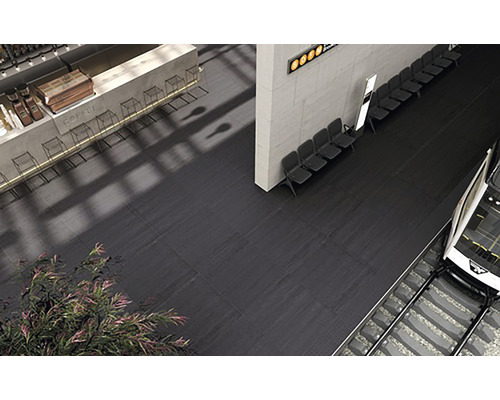 Vloertegels in een stationshal met zitplaatsen en een tram