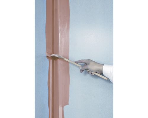 Een persoon schildert met een kwast een lat op een muur.