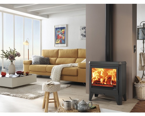 Woonkamer met kachel, bank en salontafel