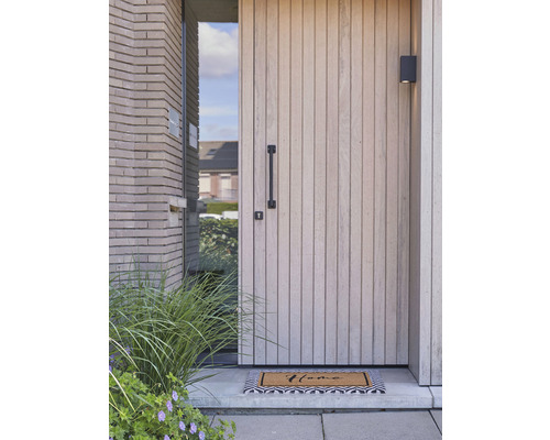 Buitenaanzicht van een modern huis met voordeur, deurgreep, buitenlamp en deurmat