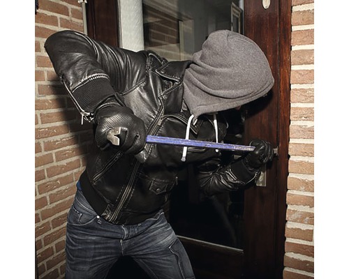 Inbreker probeert een deur open te breken met een breekijzer