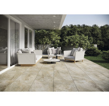 Licht terras met zitgroep, bestaande uit een bank, fauteuil en salontafel, ontworpen met vloertegels in natuursteenlook.