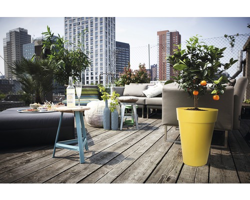 Terras met zithoek, tafel en potplanten voor flatgebouw