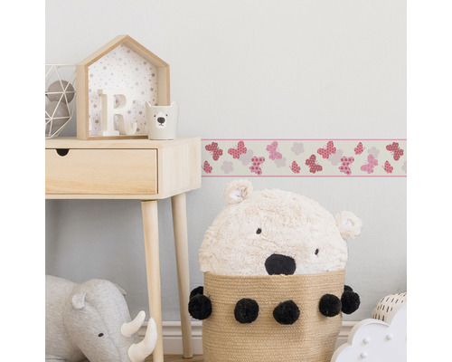 Kinderkamer met rand met vlinderpatroon en houten meubels
