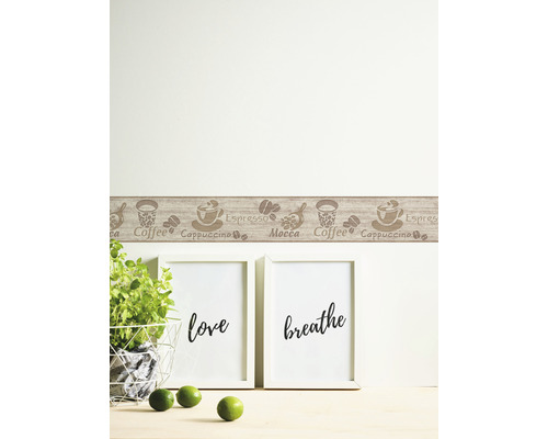 Wanddecoratie met koffiemotieven aan een muur boven twee lijsten en een plant