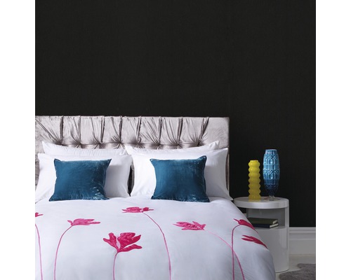 Slaapkamer met bed, gestoffeerd hoofdeinde, kussens en dekbedovertrek met bloemmotief