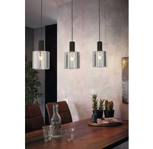 Drie hanglampen met glazen kap boven een eettafel