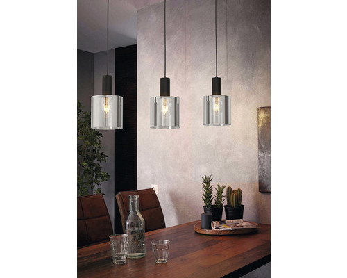 Drie hanglampen met glazen kap boven een eettafel