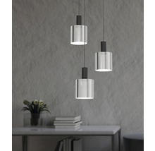 Drie hanglampen met cilindervormige glazen lampenkap hangen boven een tafel.