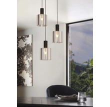 Drie hanglampen van glas en metaal hangen boven een eettafel