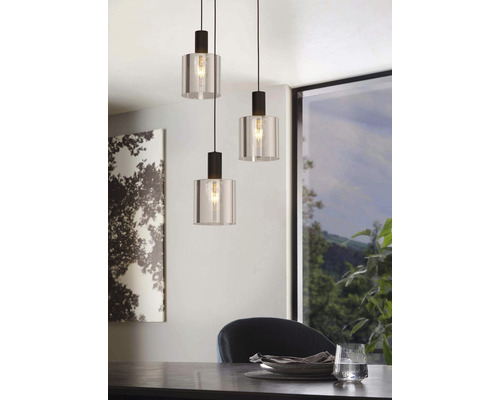 Drie hanglampen van glas en metaal hangen boven een eettafel