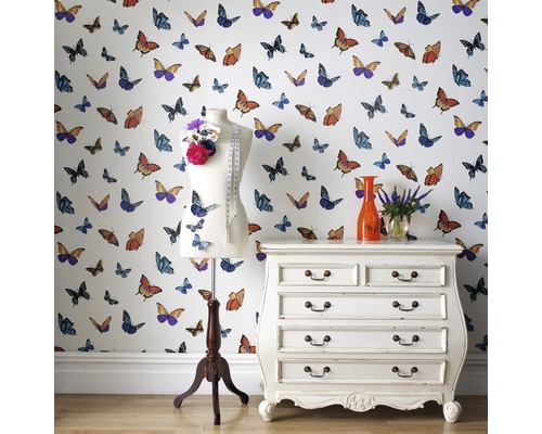 Lichte kamer met behang met vlindermotief, een paspop, een ladekast en bloemen