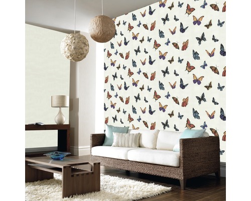 Woonkamer met behang met vlinderpatroon, bank en bijzettafel.