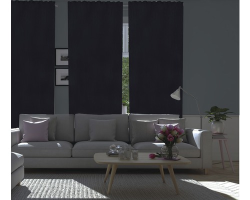 Woonkamer met schuifgordijnen voor het raam, bank, salontafel en decoraties.