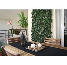 Terrasscène met houten tafel, stoelen, decoratie en kunsthaag