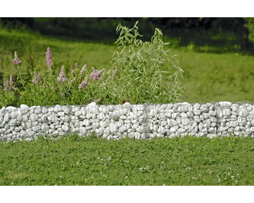 Schanskorfmuur met witte stenen in de tuin