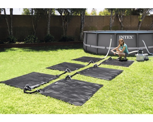 Installatie van zonneverwarmingsmatten voor een zwembad in de tuin