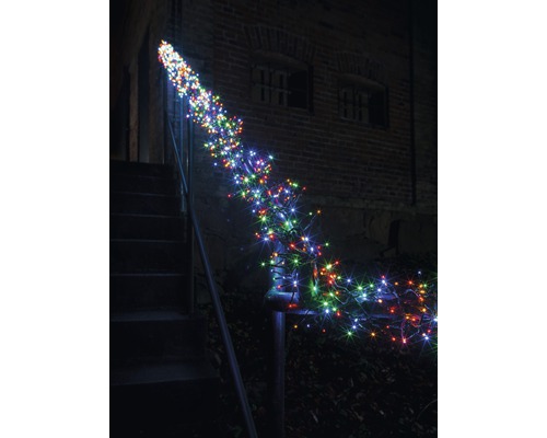 Decoratieve lichtketting kronkelt rond een trapleuning buitenshuis.