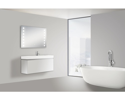 Badkamer met wastafel, verlichte spiegel en bad