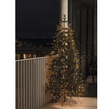 Kunstkerstboom met verlichting op een balkon.